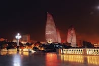 巴库火焰塔的夜景充满戏剧性，其发光的红色灯光映照着城市景观
