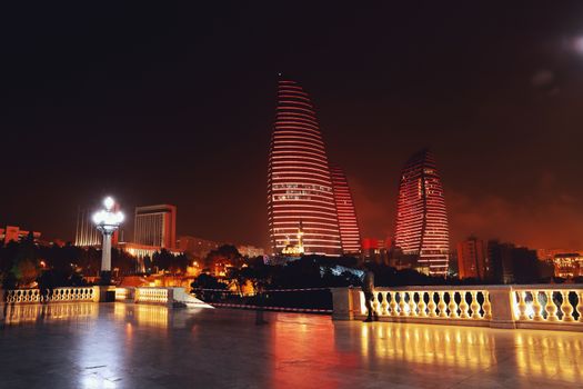 巴库火焰塔的夜景充满戏剧性，其发光的红色灯光映照着城市景观