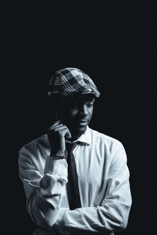 Free Elegant black and white portrait of a man wearing a beret and tie, evoking classic style. Stock Photo