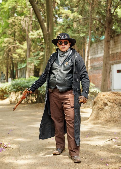Free A steampunk enthusiast poses in a forest wearing vintage attire and accessories. Stock Photo