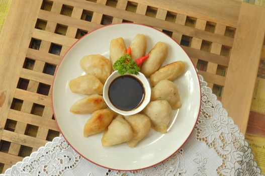 Top view of Indonesian dumplings with soy dipping sauce, garnished with red chili and parsley. - Fotografer Sidoarjo