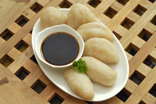Delicious traditional Indonesian Pempek served with soy sauce on a wooden table for a perfect meal.