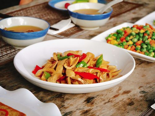 Free A vibrant vegetable dish with peppers and beans served on a rustic table, perfect for food photography. Stock Photo