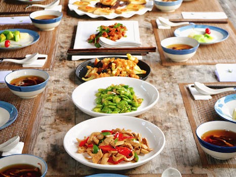 A beautifully arranged table with a variety of traditional Asian dishes.