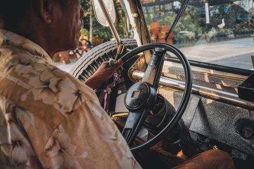 Free Close-up of a man driving a vintage car with focus on the dashboard and steering wheel. Stock Photo