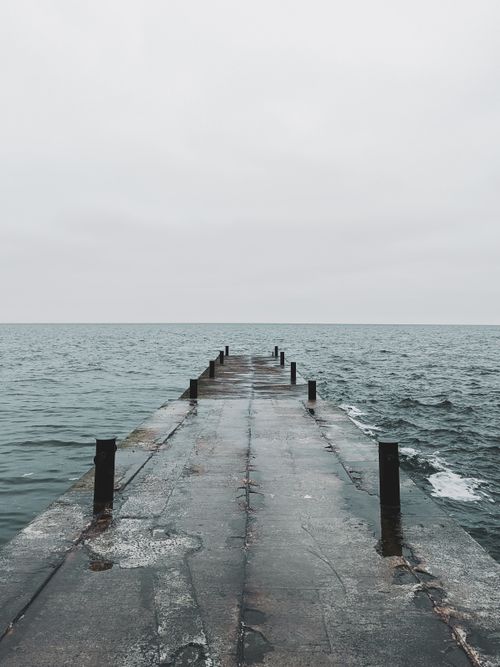 Free A tranquil view of an ocean pier extending into the horizon, creating a peaceful scene. Stock Photo