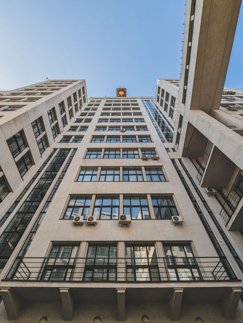 Free Low angle view of a modern skyscraper facade in Kharkiv, Ukraine, under a crisp blue sky. Stock Photo
