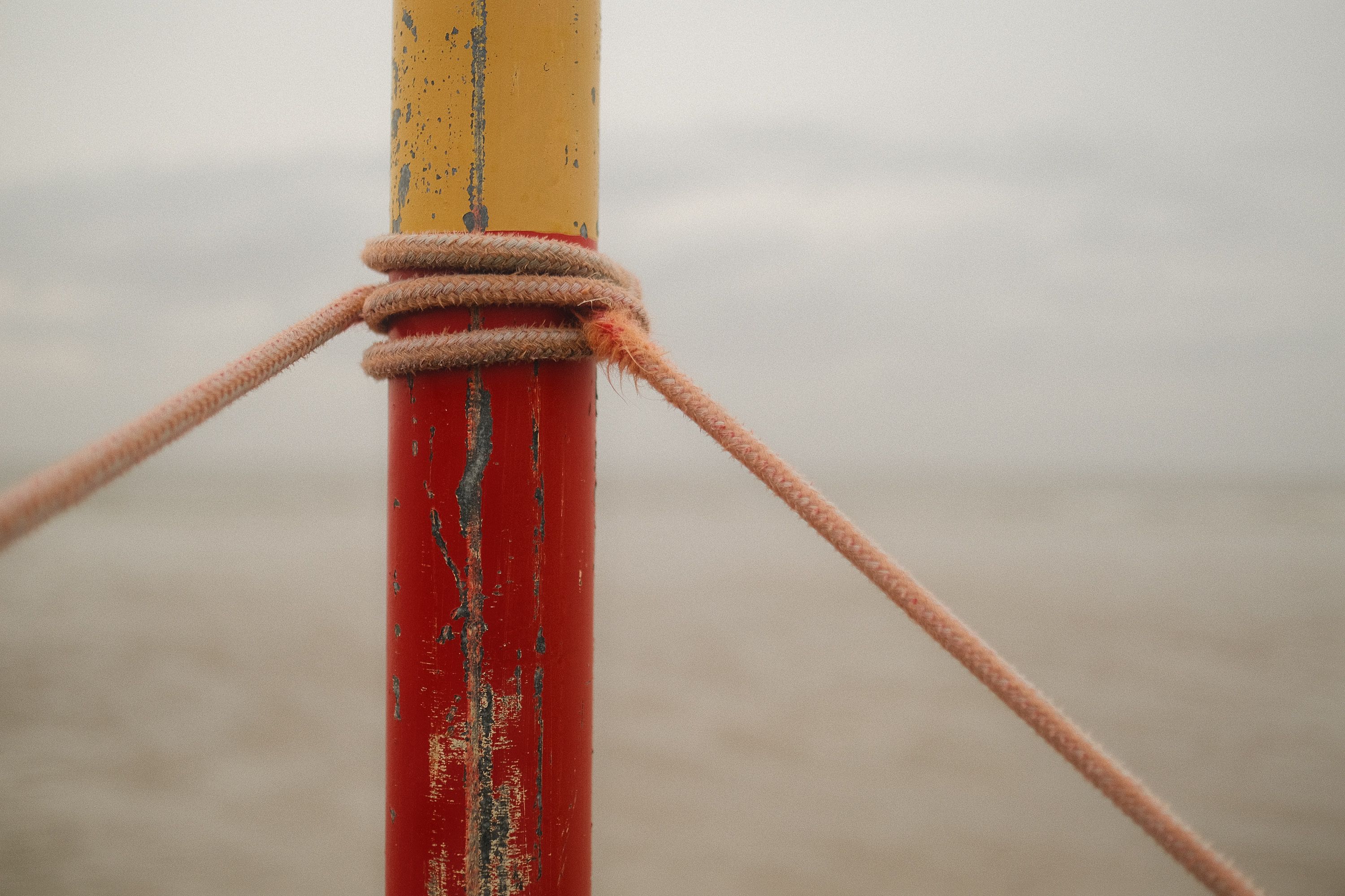 A rope tied to a pole on the beach · Free Stock Photo