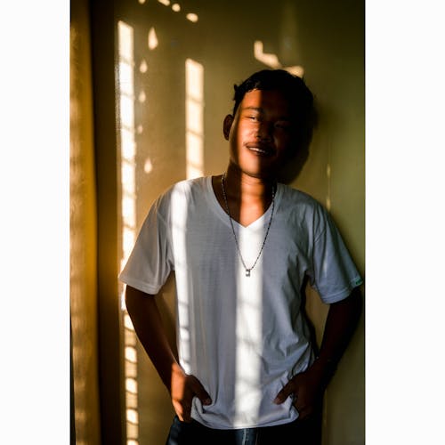 Man Wearing White V-neck Shirt Leaning on Wall