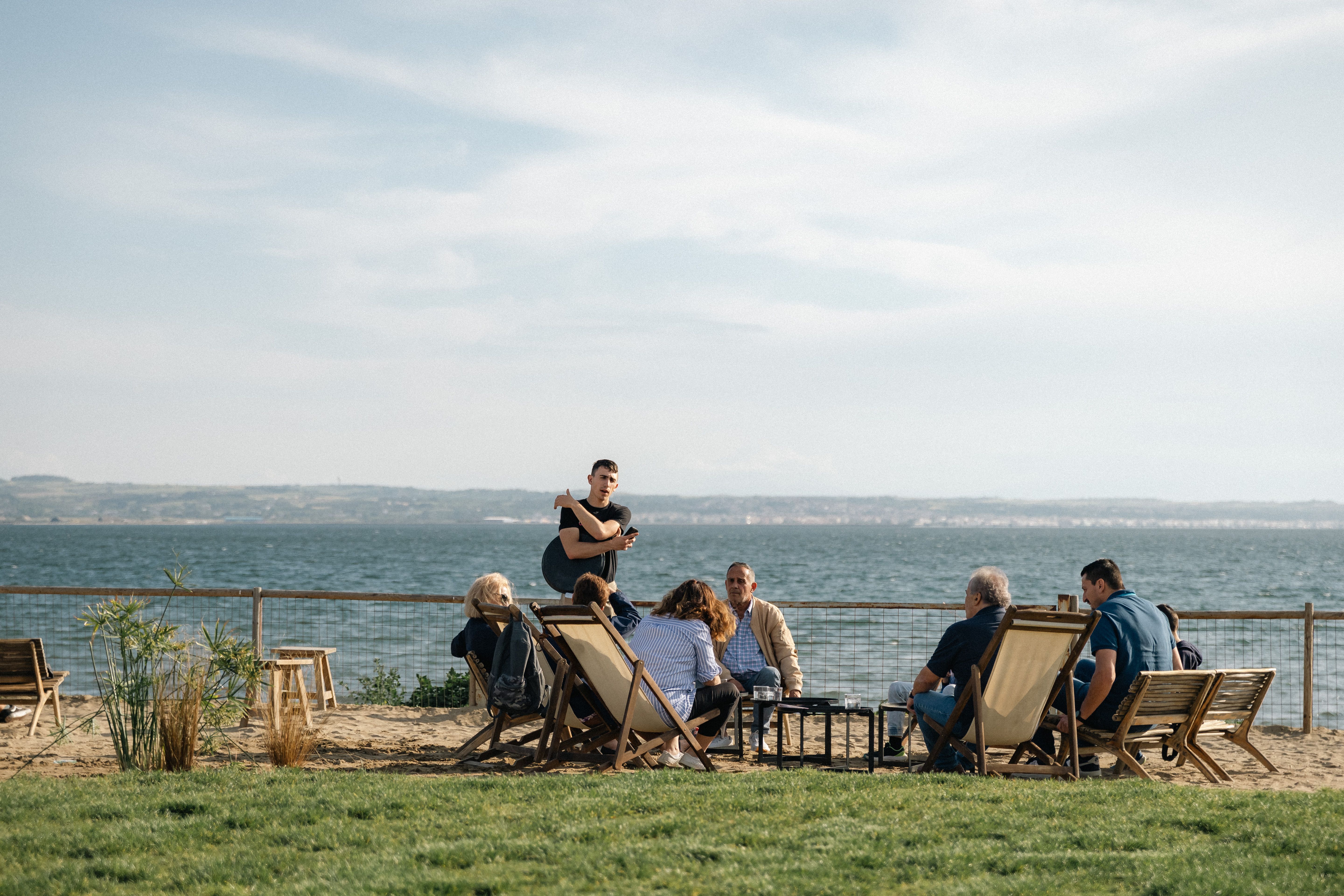 People sitting on chairs near the water · Free Stock Photo