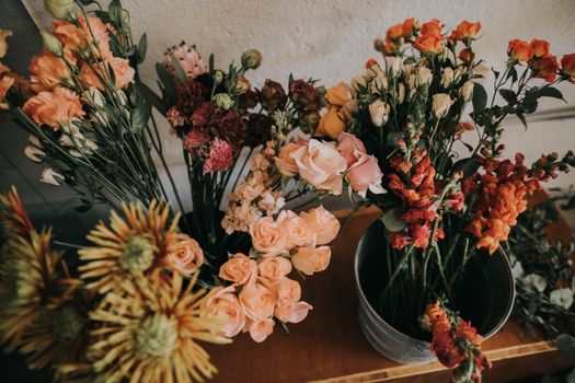 A beautiful display of colorful assorted flowers in a rustic indoor setting.