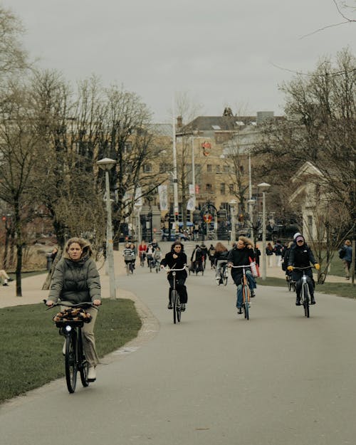 A group of people riding bikes down a street