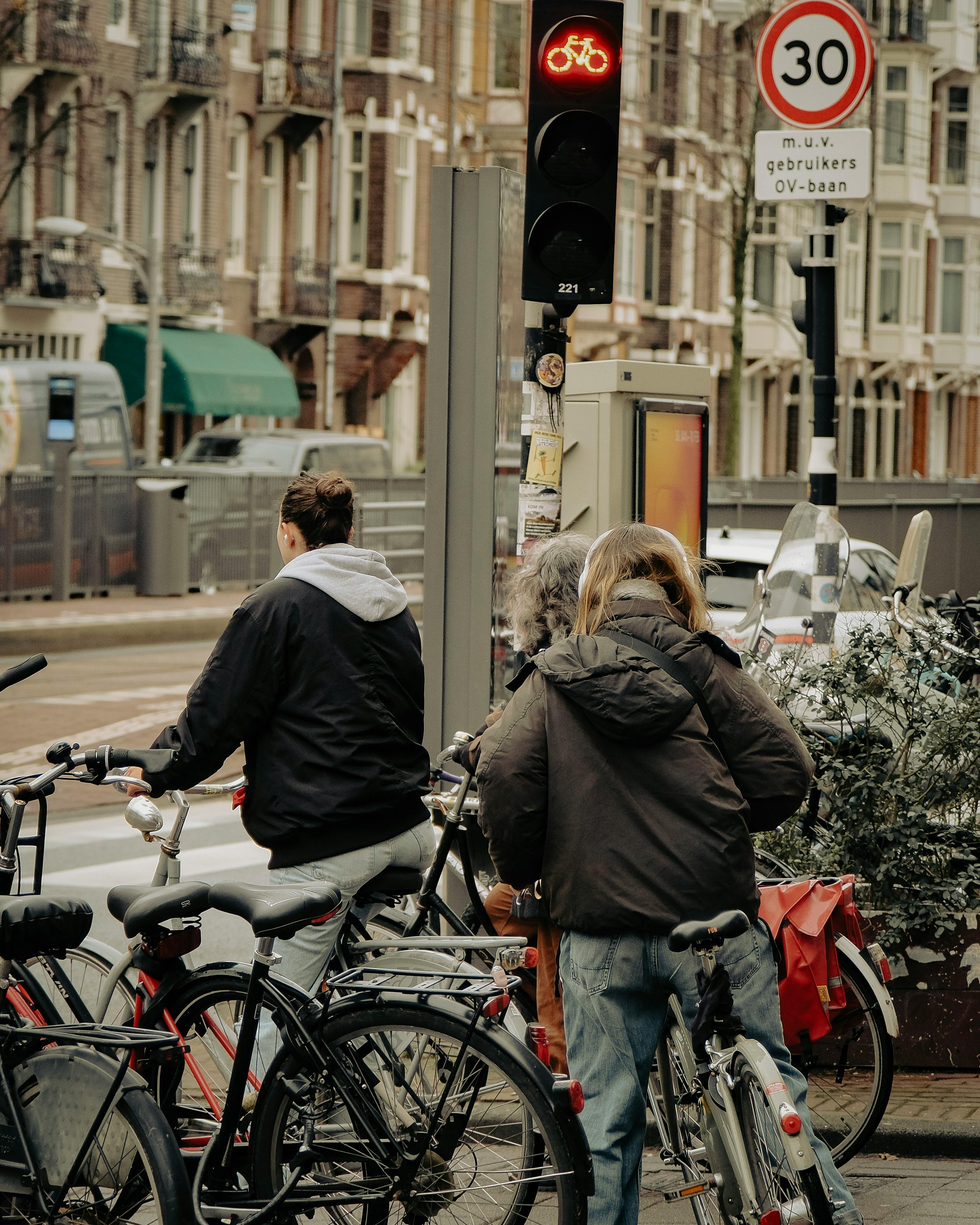 Ciclistas urbanos parados em semáforo de bicicleta