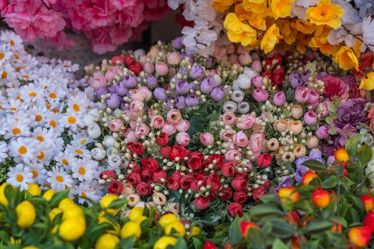 Colorful artificial flower arrangement at a market in İzmir, Türkiye.
