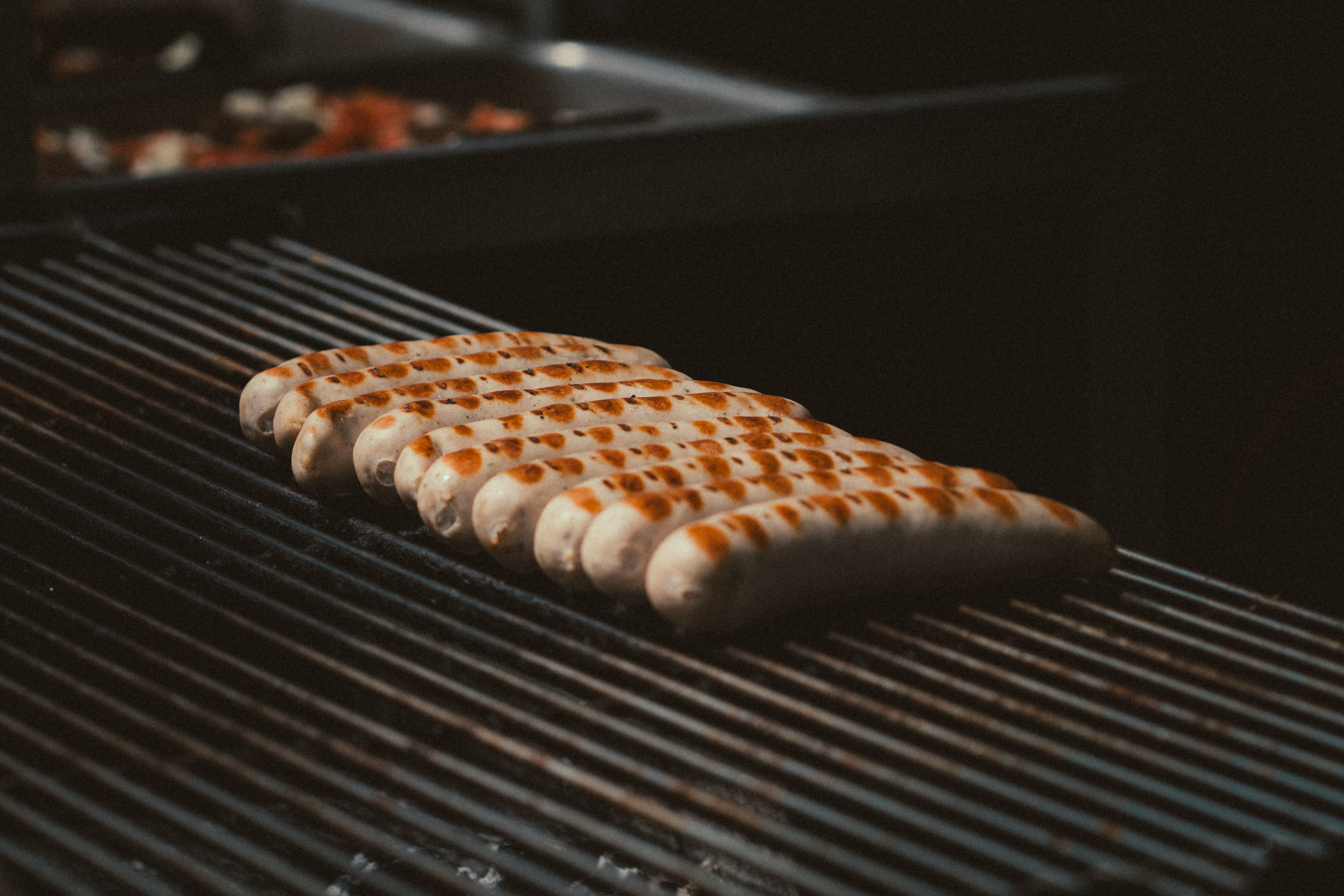 Close-up of delicious sausages grilling on a barbecue with perfect sear marks.