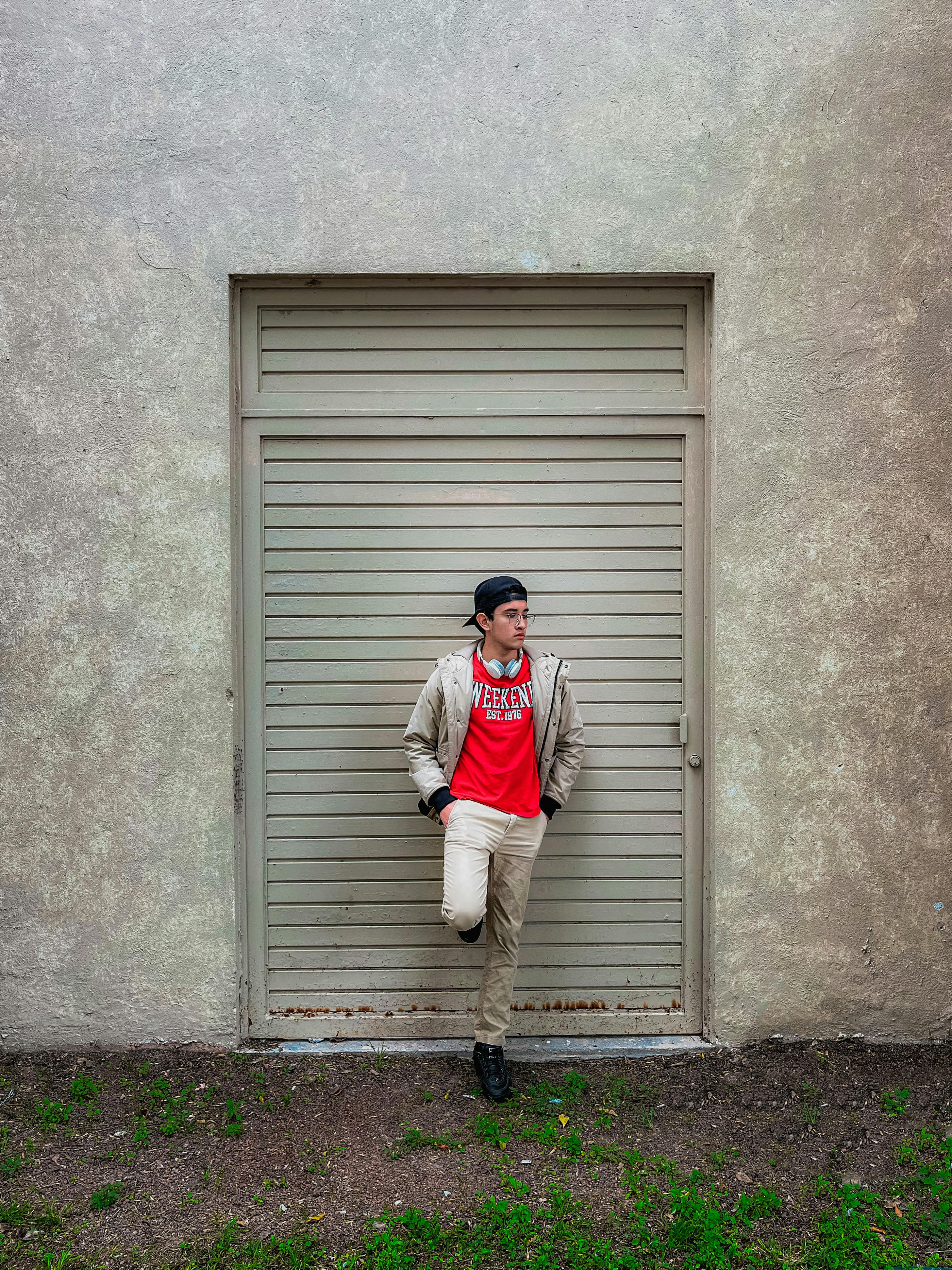 young man leaning on a metal door