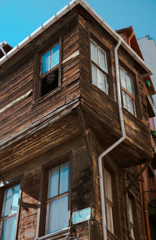 A wooden house with a window and a cat