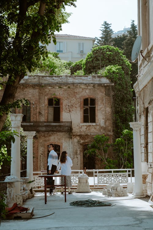 A couple walking down a path in front of an old building