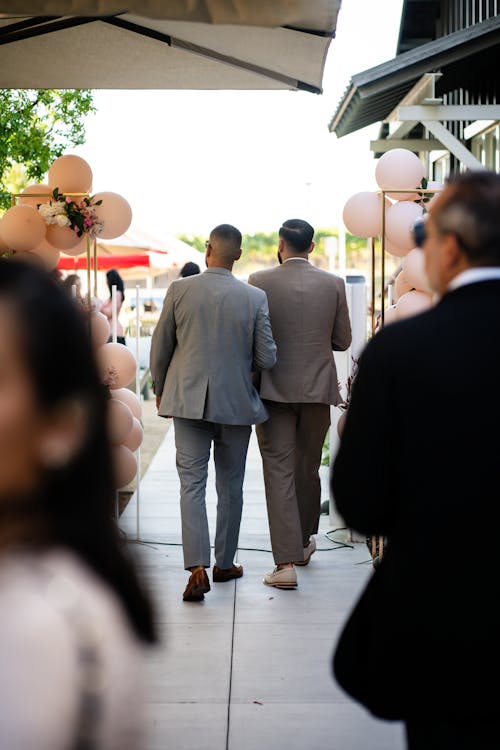 Two men walking down the aisle with balloons