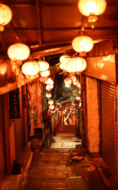 Free Charming Asian alleyway illuminated by traditional lanterns at night, showcasing cultural beauty. Stock Photo