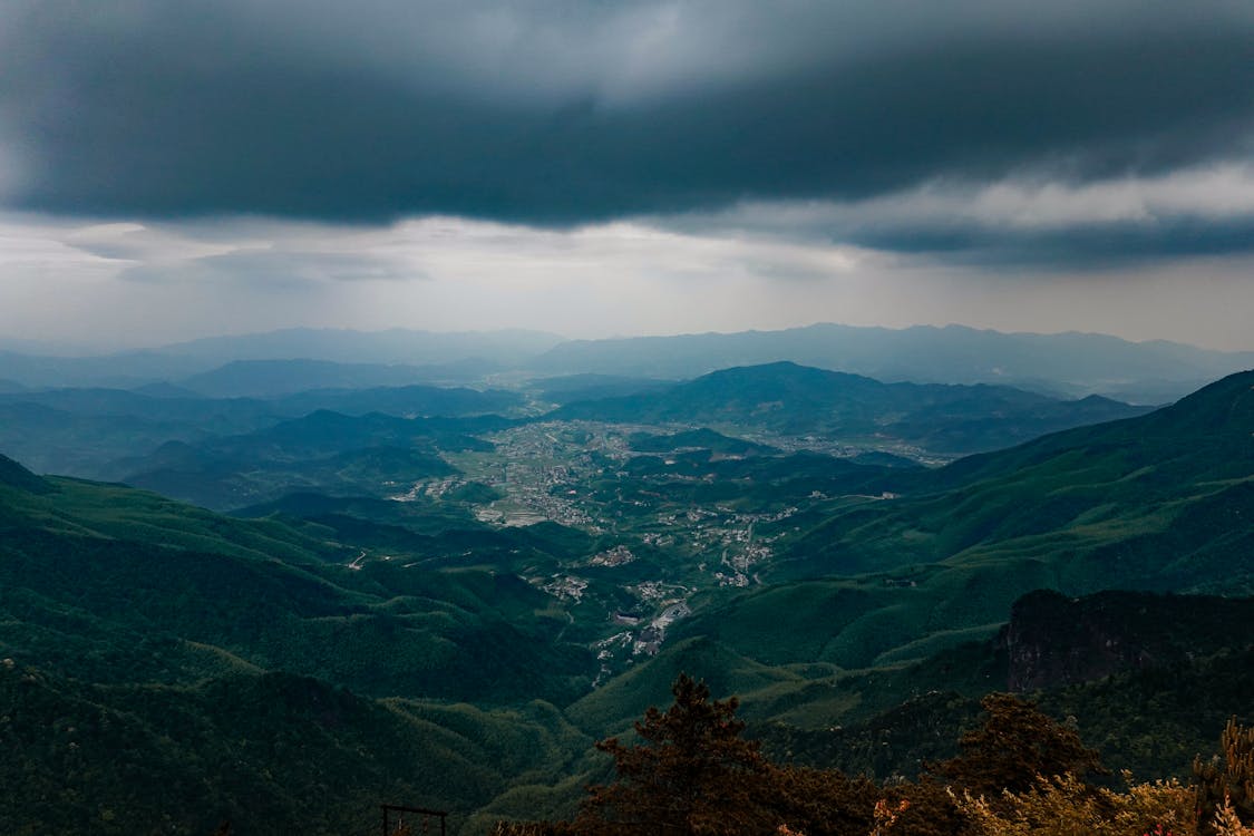 Free Scenic view of mountains and valley under dark storm clouds in Pingxiang, Jiangxi, China. Stock Photo