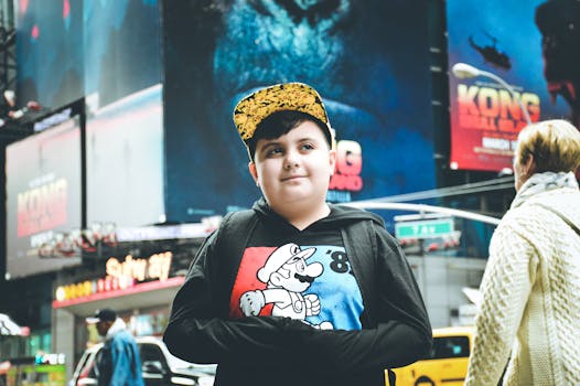 一个小男孩穿着卡通连帽衫，站在纽约时代广场