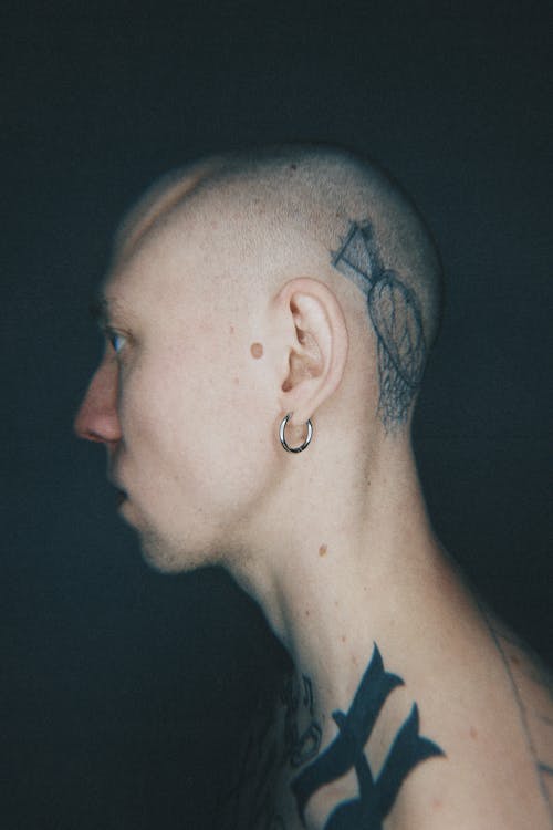 A man with tattoos on his head and neck