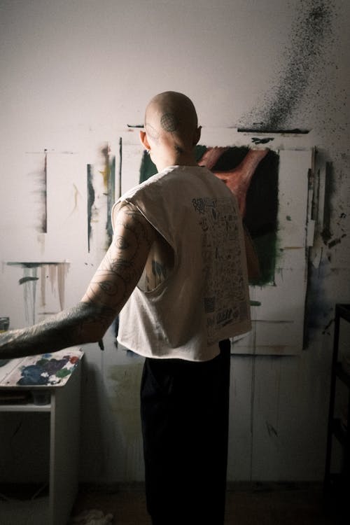 A man with a tattooed arm in an art studio