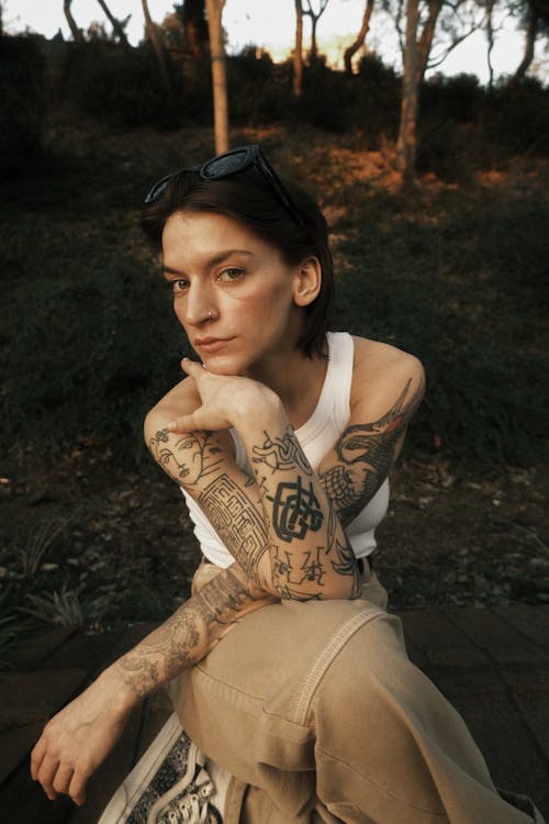 Woman with Tattoos Sitting in Forest