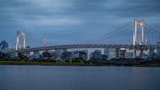 在蓝色时刻，以城市天际线为背景，拍摄横跨东京湾的彩虹桥