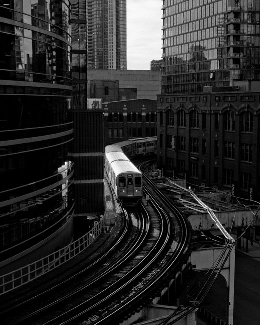 Monochrome shot of a Chicago elevated train moving through the bustling downtown area.