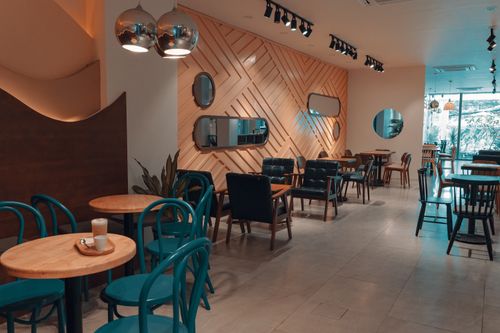 Free Explore a modern cafe interior featuring stylish chairs, tables, and lighting design. Stock Photo
