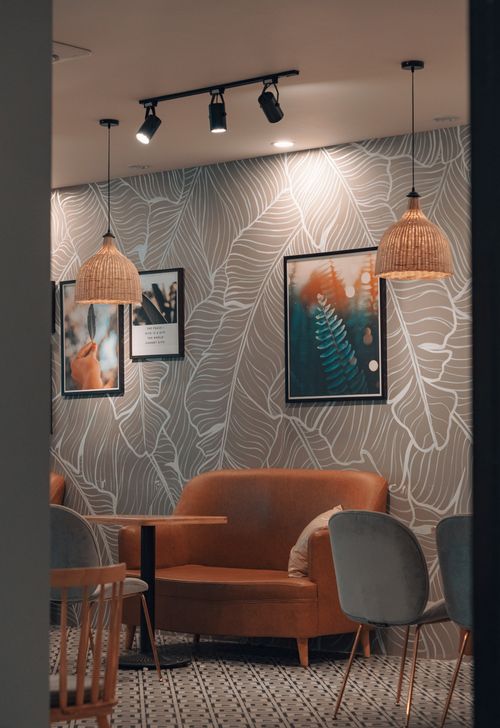 Free Stylish café interior with modern art, minimalist furniture, and warm lighting creating a cozy atmosphere. Stock Photo