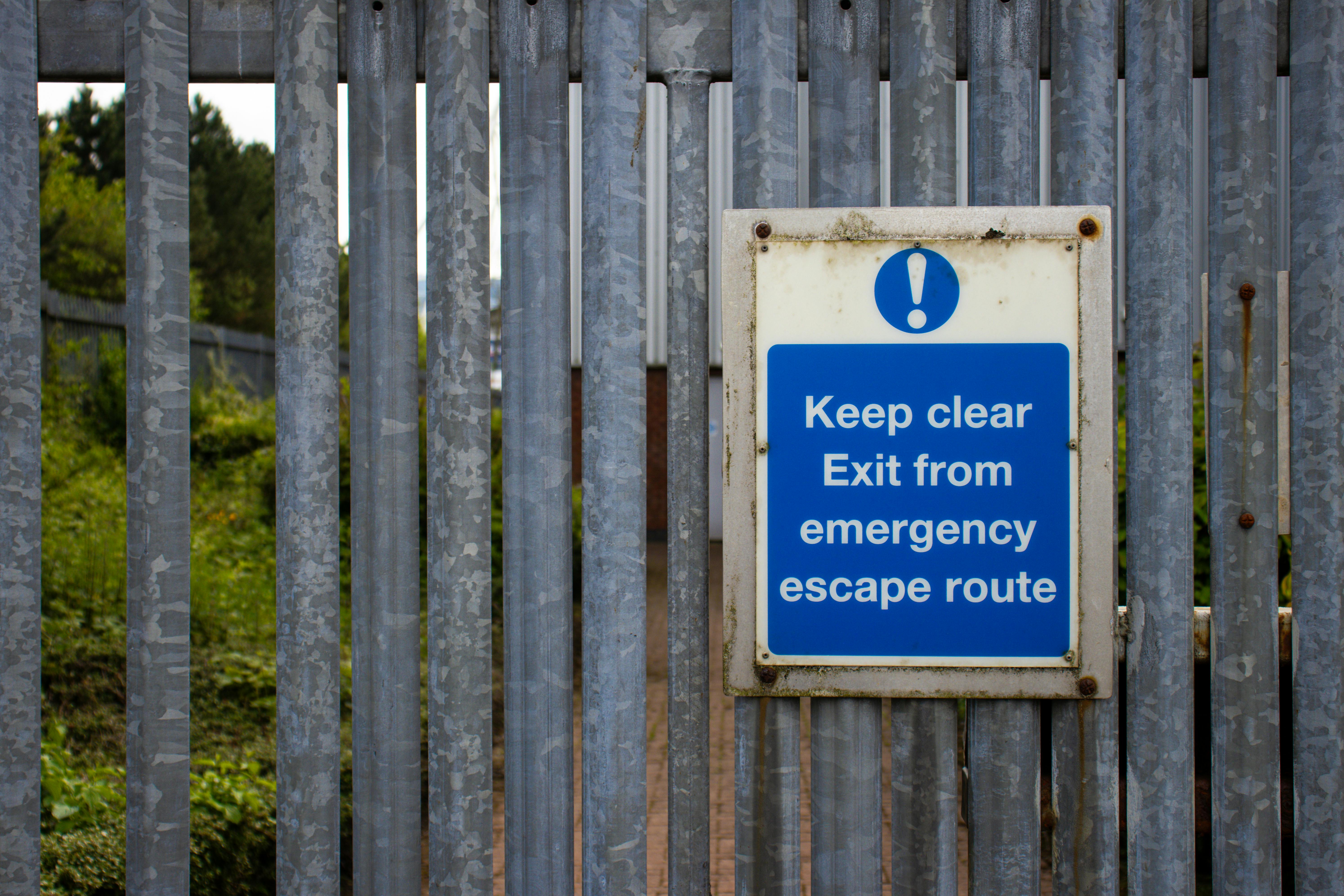 a sign hanging on a metal fence