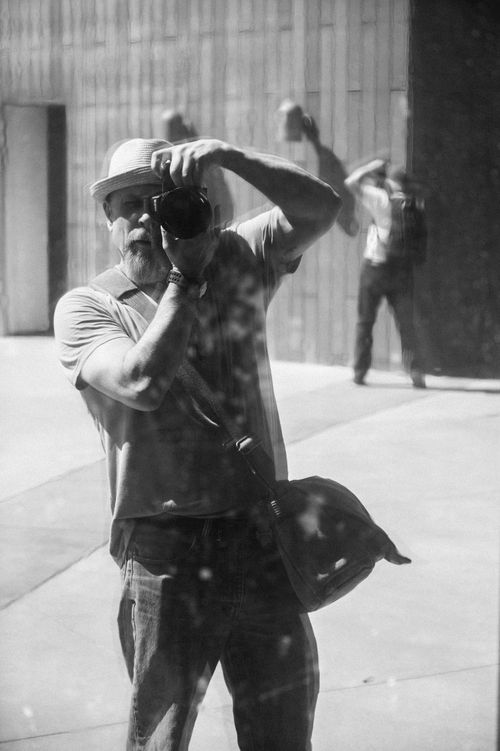 Free Black and white photograph of a man in a hat taking a selfie in a reflective window in Boise, ID, USA. Stock Photo