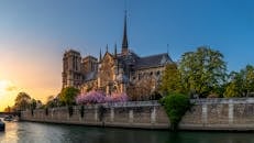 沐浴在温暖的日落灯光下，巴黎圣母院大教堂享有河景