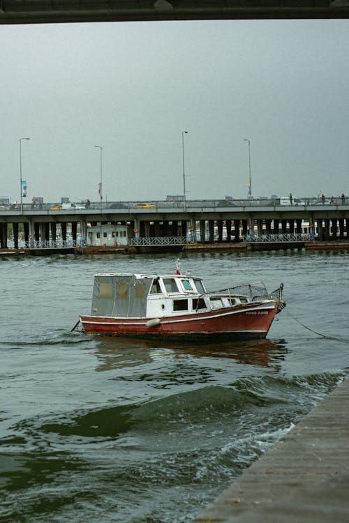 A boat is docked in the water near a bridge