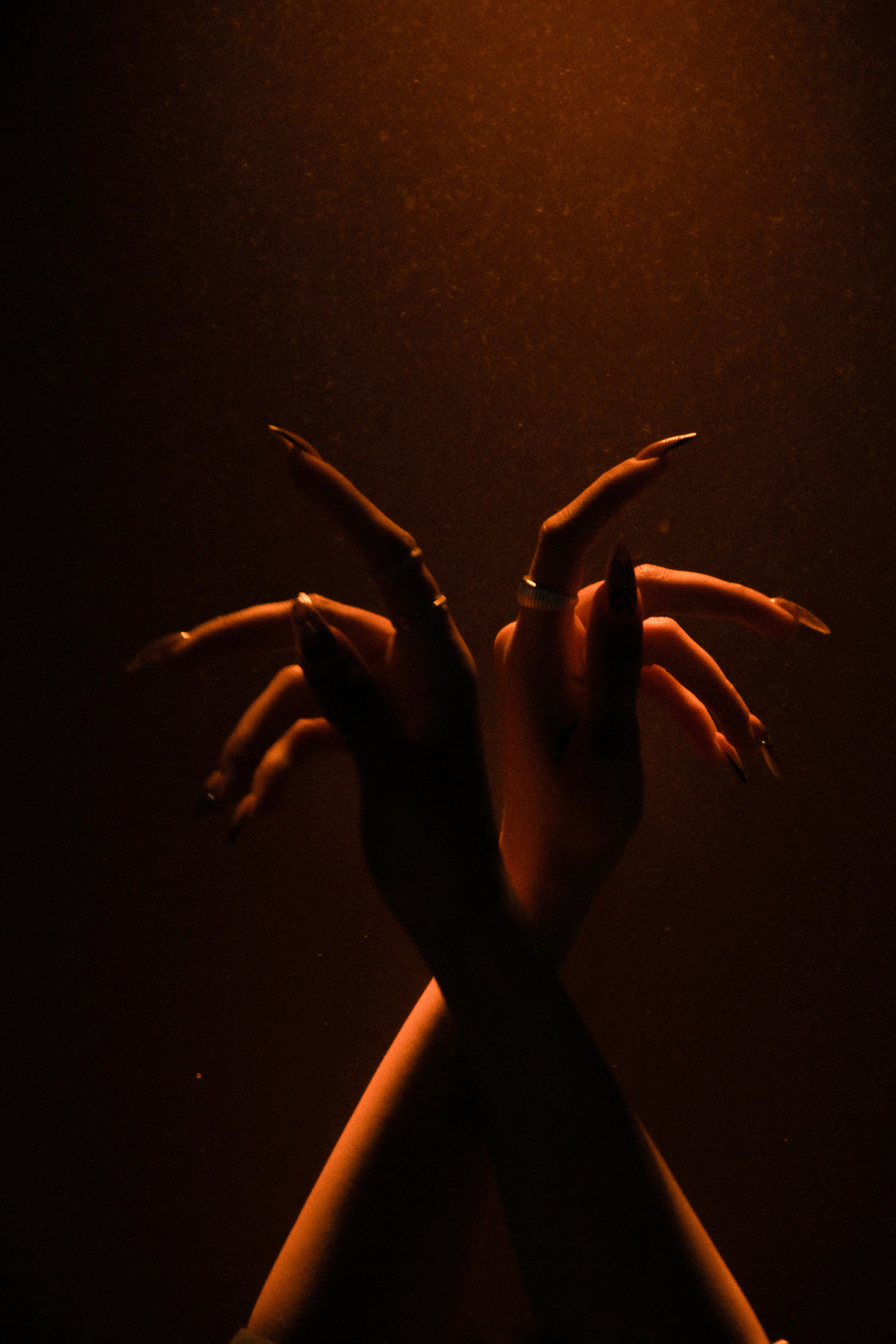 Close-up of Raised Female Hands in Red Lighting · Free Stock Photo