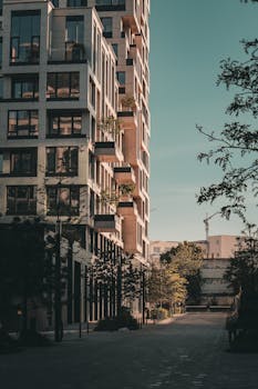 A modern high-rise residential building captured during sunset in an urban setting.