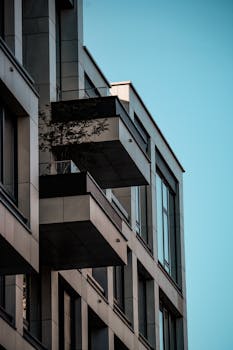 Contemporary urban apartment building with multiple balconies and modern design elements.