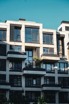 Contemporary apartment building facade with balconies and clear blue sky.