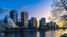 日落时分，河畔的现代摩天大楼勾勒出令人惊叹的巴黎天际线