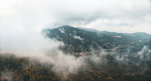 A view of a valley with clouds and mountains
