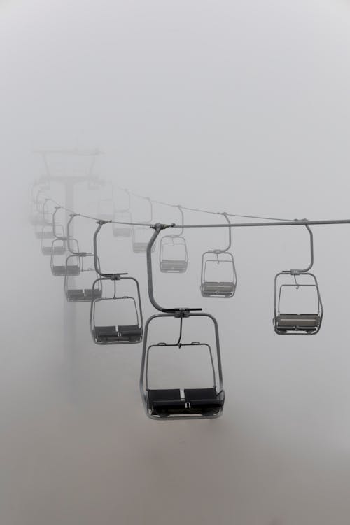 A ski lift in the fog with a line of people