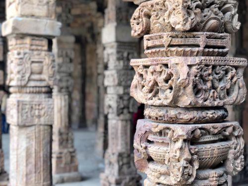 Free Detailed view of ornate stone pillars in an ancient Indian temple showcasing historic art. Stock Photo