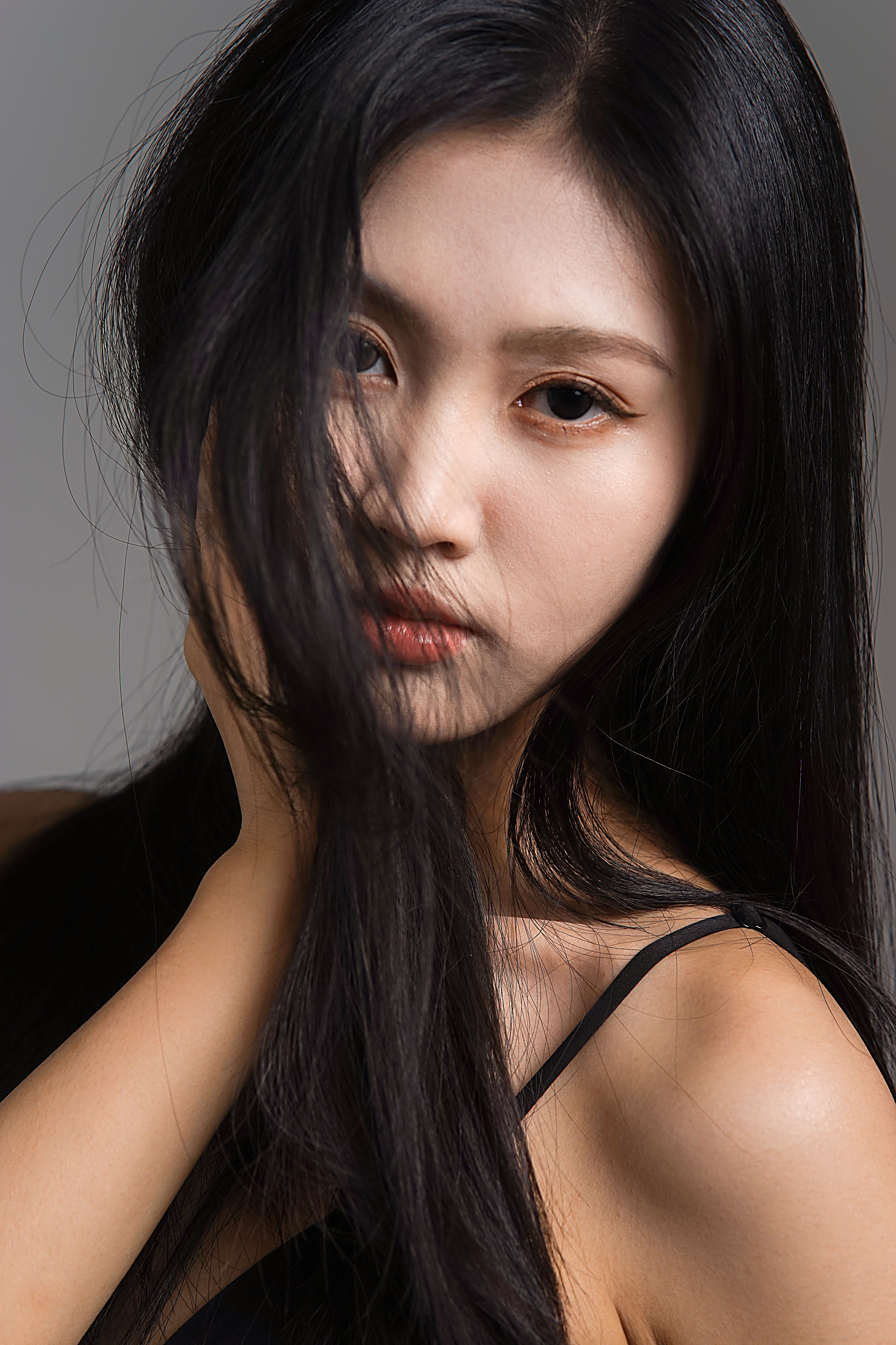 Closeup portrait of a young Asian woman with long black hair, showcasing elegance and beauty.
