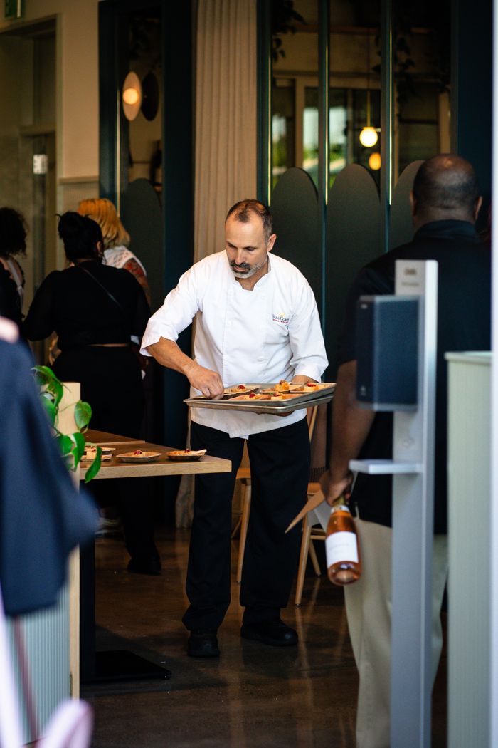 Server presenting dishes from a tray in the dining room