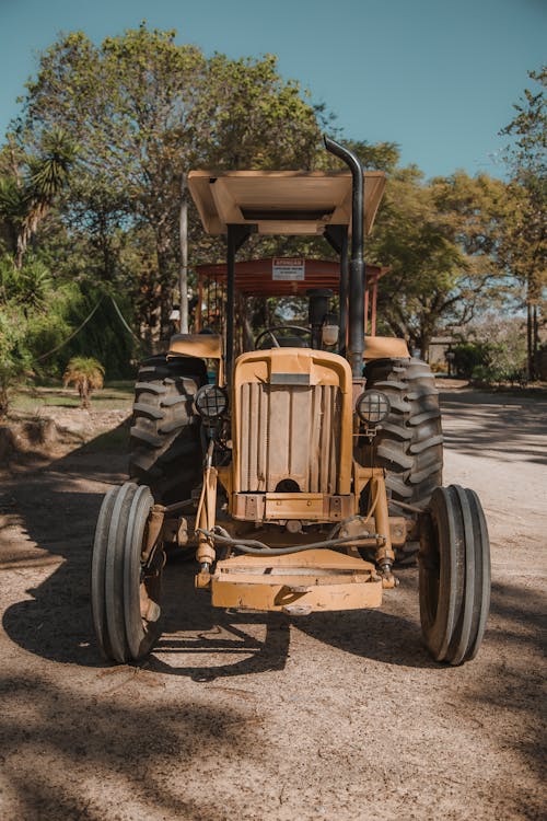 A vintage tractor parked in the middle of a road