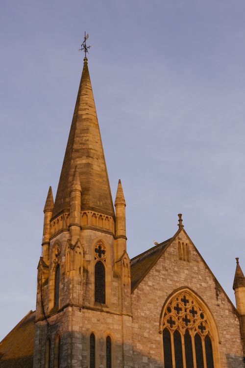 Free A stunning Gothic church spire reaching towards the sky at sunset. Stock Photo