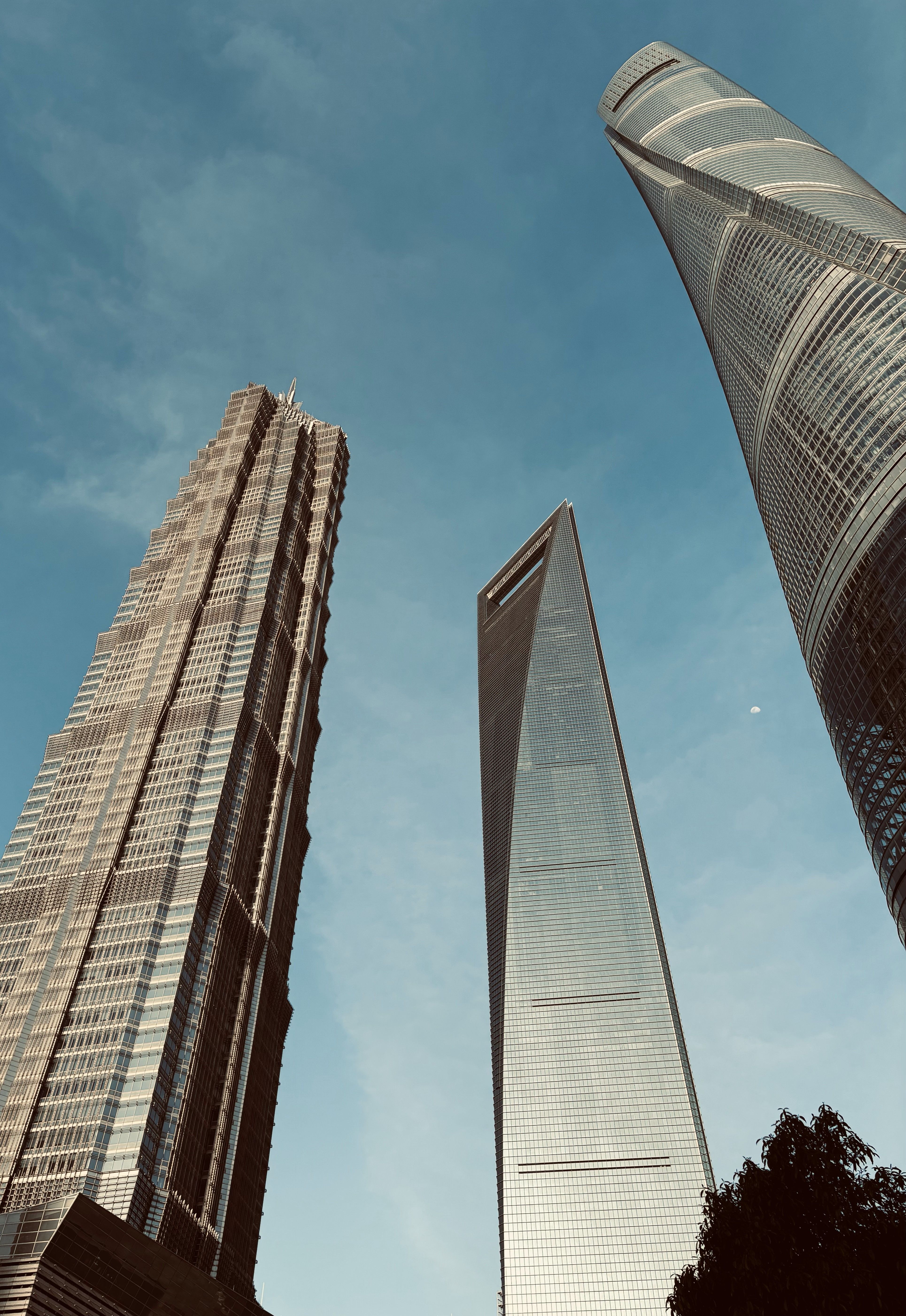 Low angle view of iconic skyscrapers in Shanghai's Lujiazui district under a clear sky.